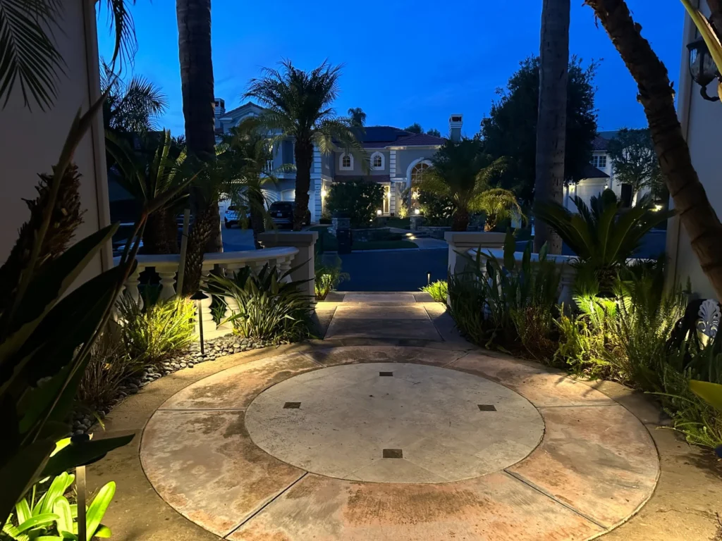 Circular driveway with garden uplighting at dusk