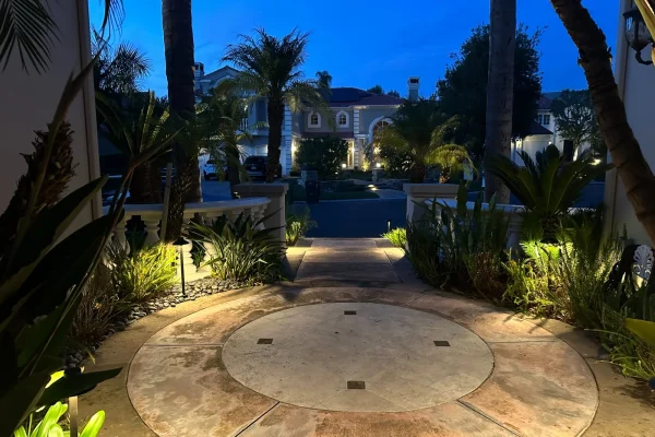 Circular driveway with garden uplighting at dusk