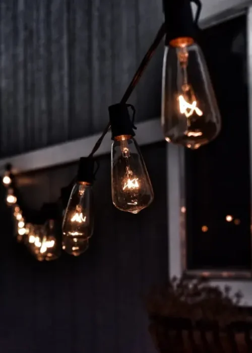 Warm hanging string lights creating cozy outdoor patio lighting at night