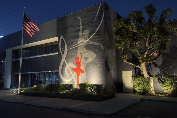 Commercial exterior lighting installation in Orange County CA with full building facade uplighting, tree accent lighting, and hedge landscape lighting at night